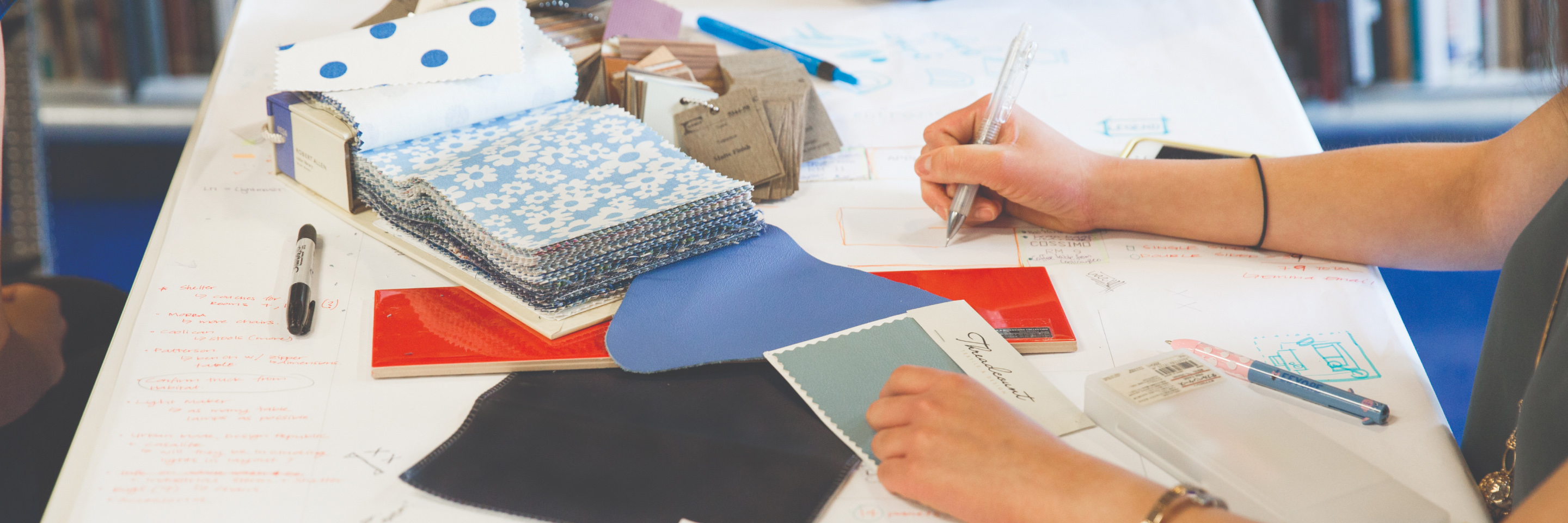 Sketchbook and pieces of materials on a study table