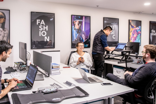 Two students working in a office with Fashion posters on the background
