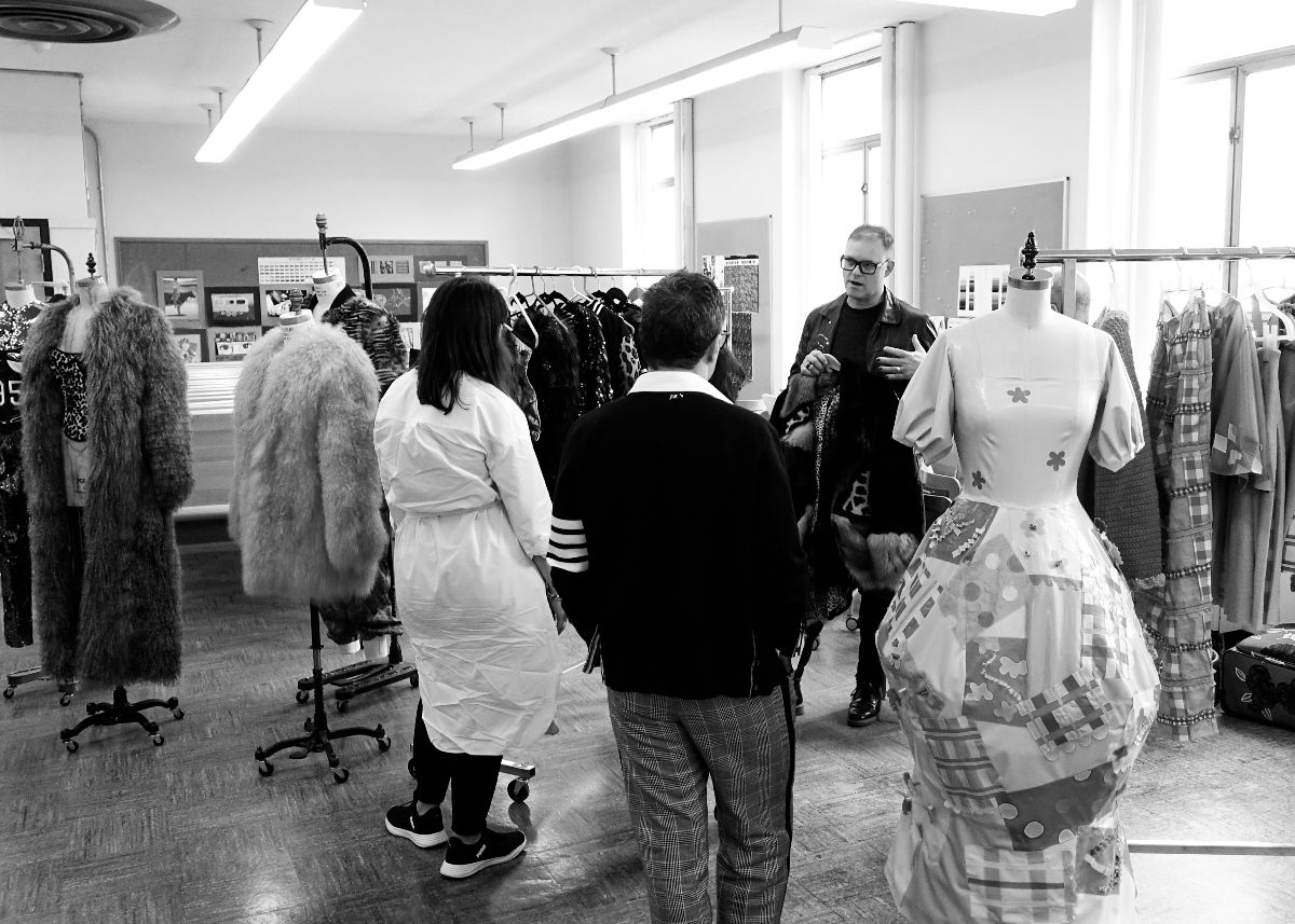 Director, Robert Ott with Selection Committee holding a garment.