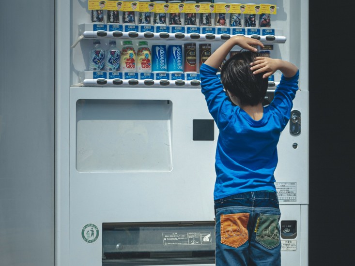 boy staring at a vending machine