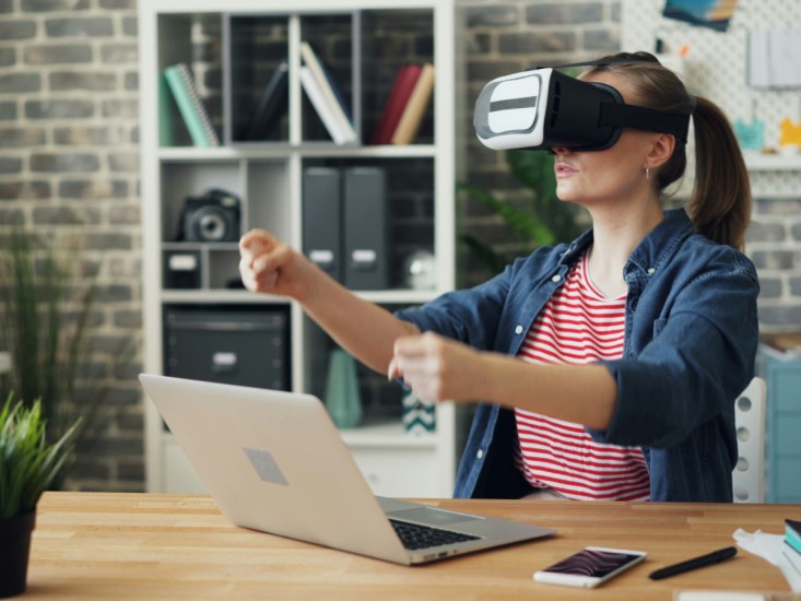 woman simulating driving with virtual reality glasses