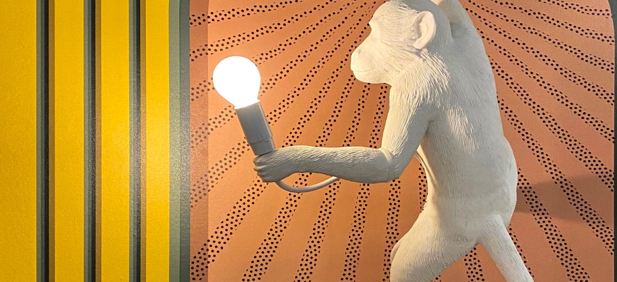 monkey sculpture holding a light bulb