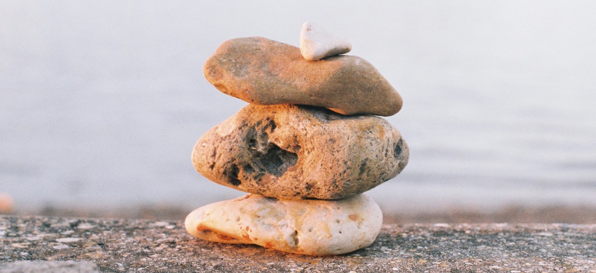 three stones balanced on each with a small pebble on the top