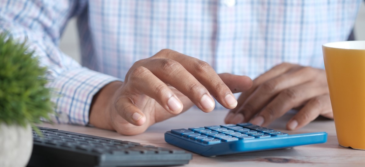 a person's hands on calculator and keyboard