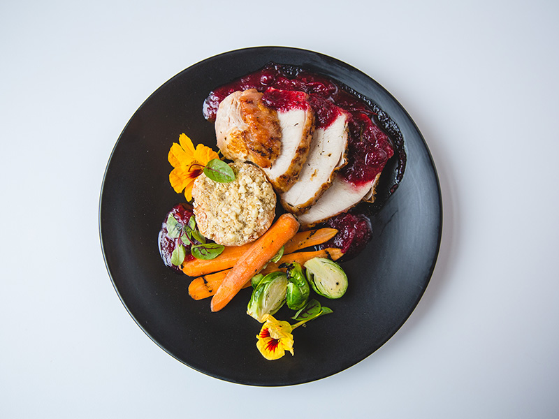 A holiday menu plate with turkey, cranberry sauce, stuffing and veggies from the TMU Eats holiday menu.
