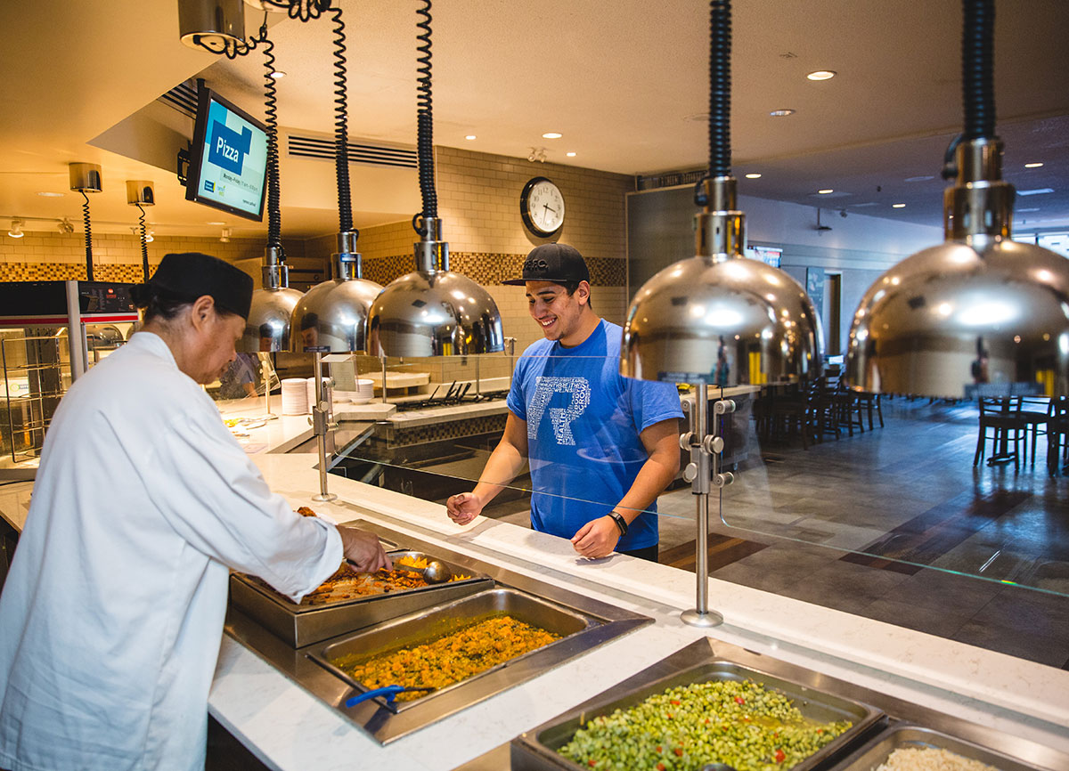 A student being served by a chef in the ILC dining hall.
