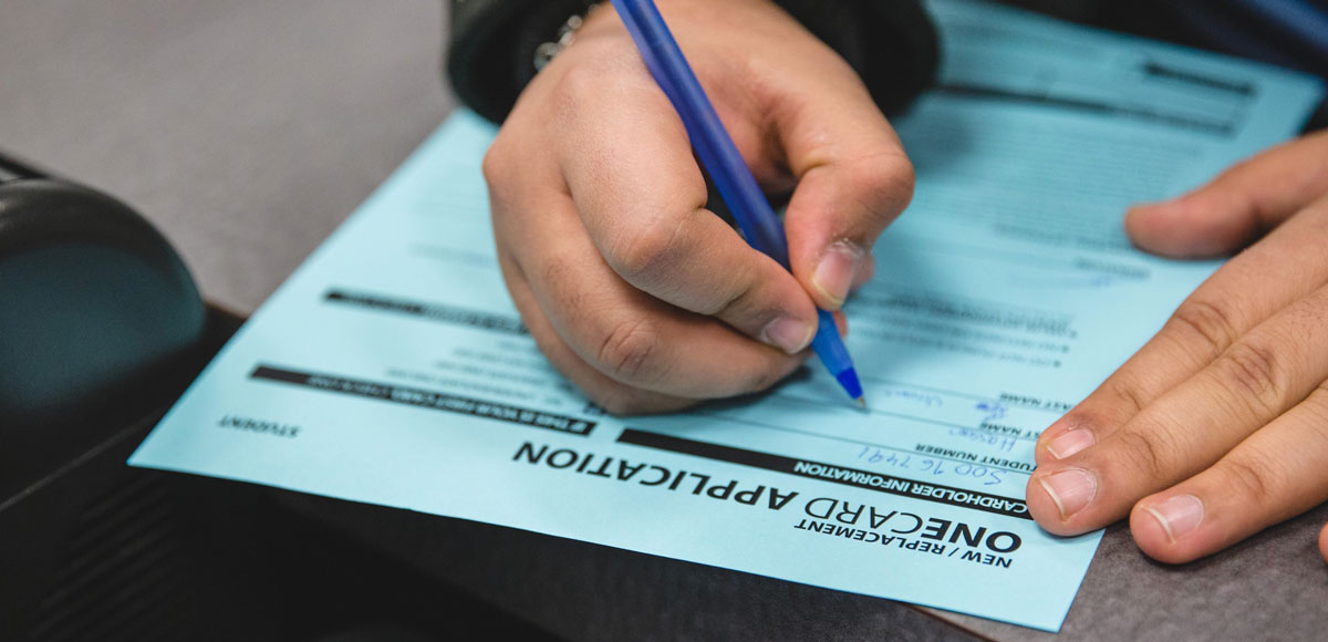 Close-up of a person's hands filling out a form.