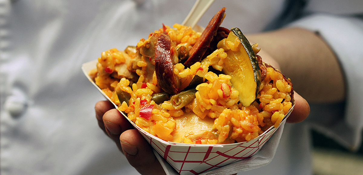 An outstretched hand holding a portion of fried rice.