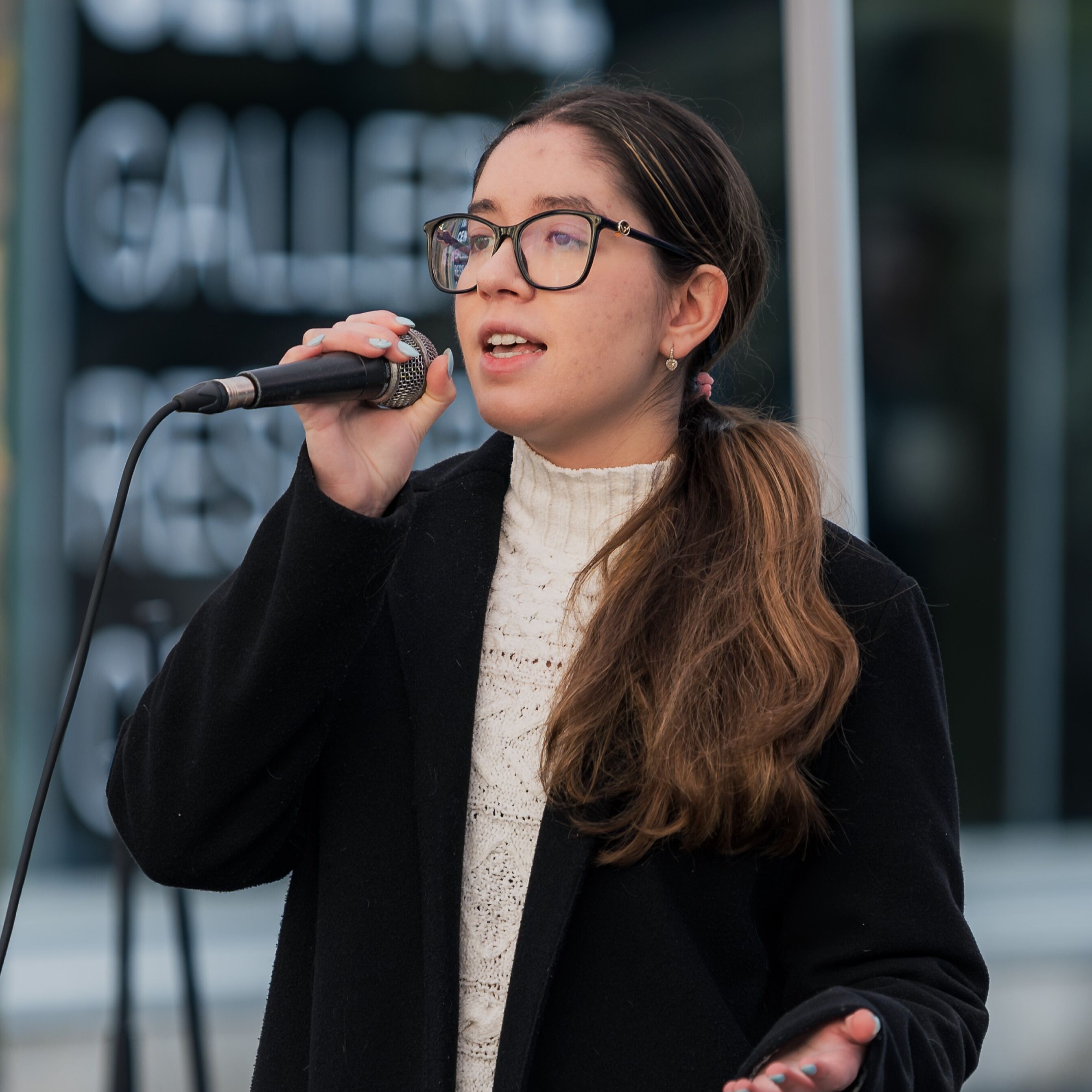 Ariyanna holding microphone, singing.