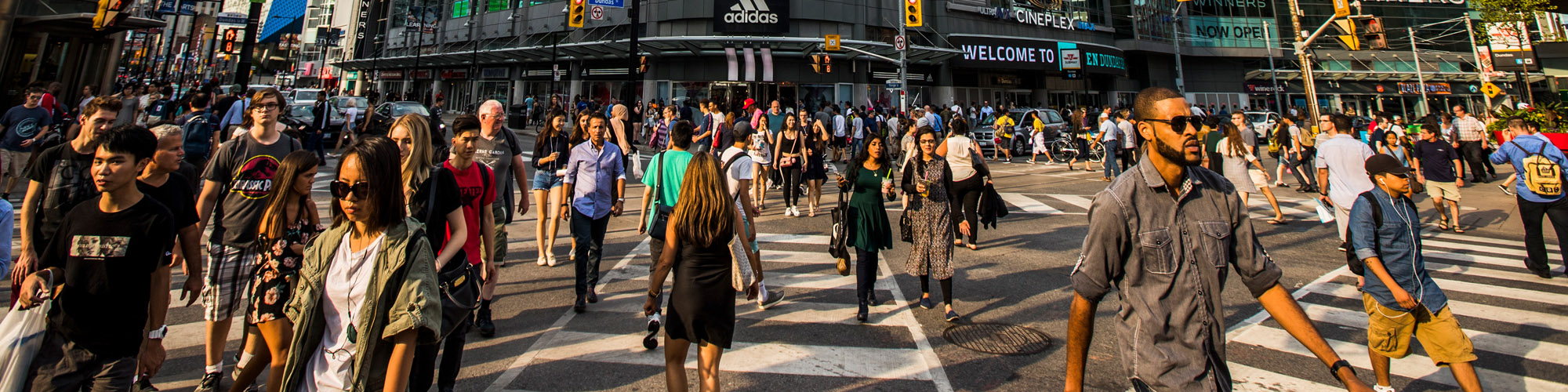 Crowd walking across Yonge St and Dundas Toronto
