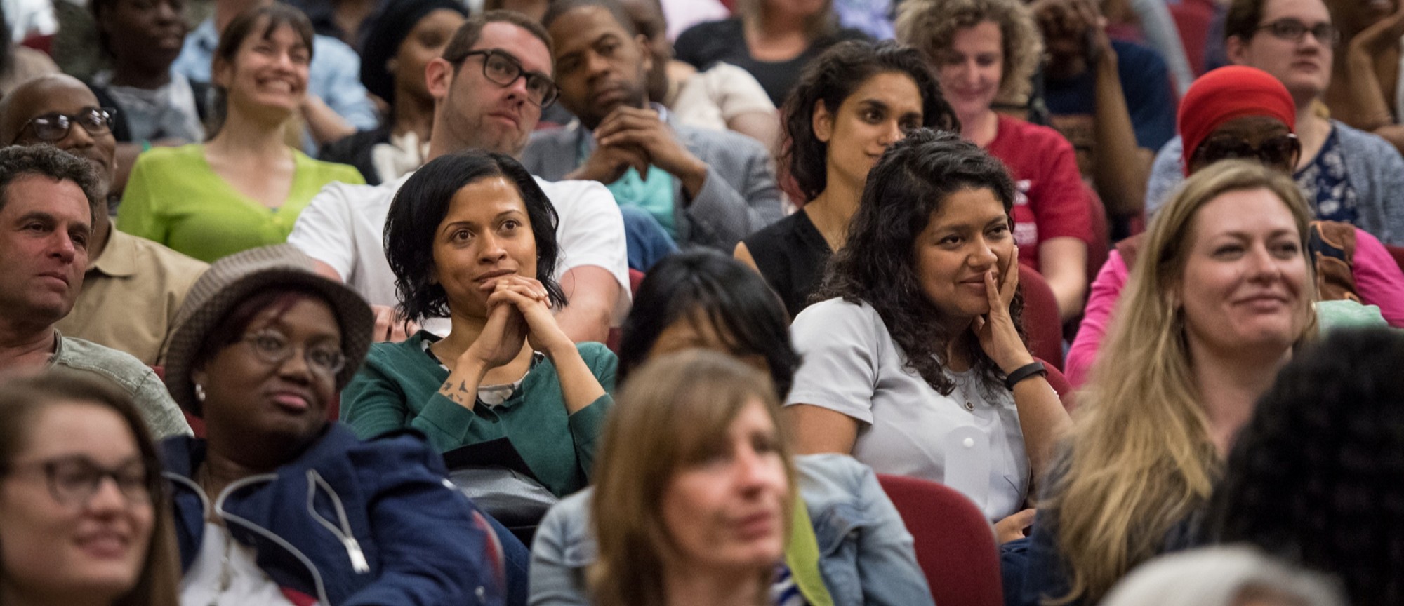 Audience members listening attentively during a large event.