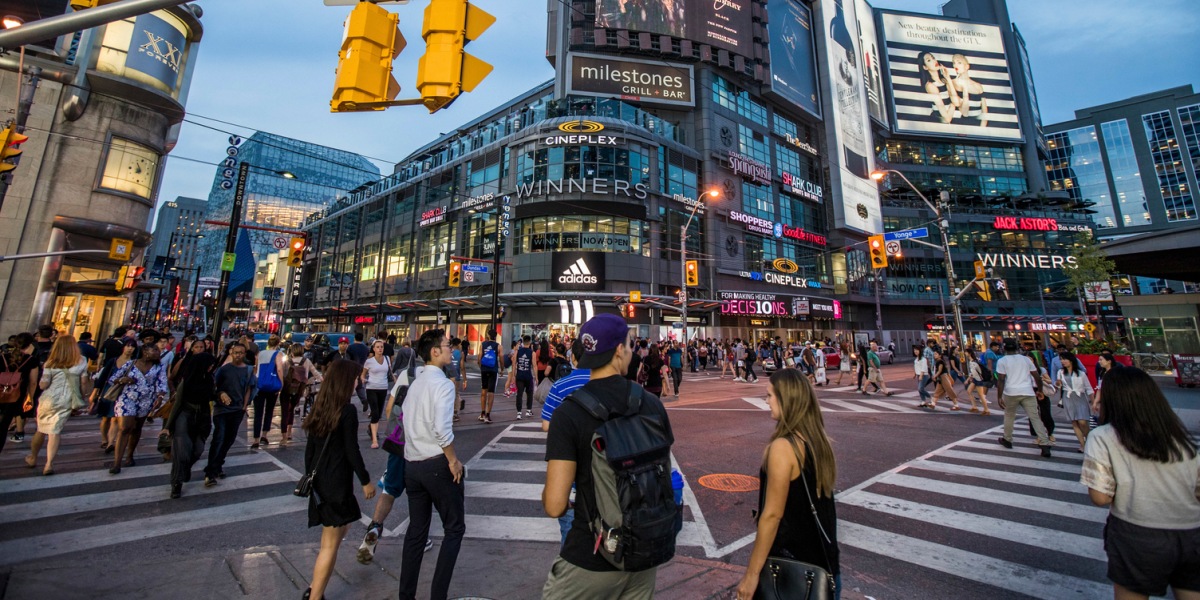 Busy intersection at Yonge and Dundas in twilight with pedestrians