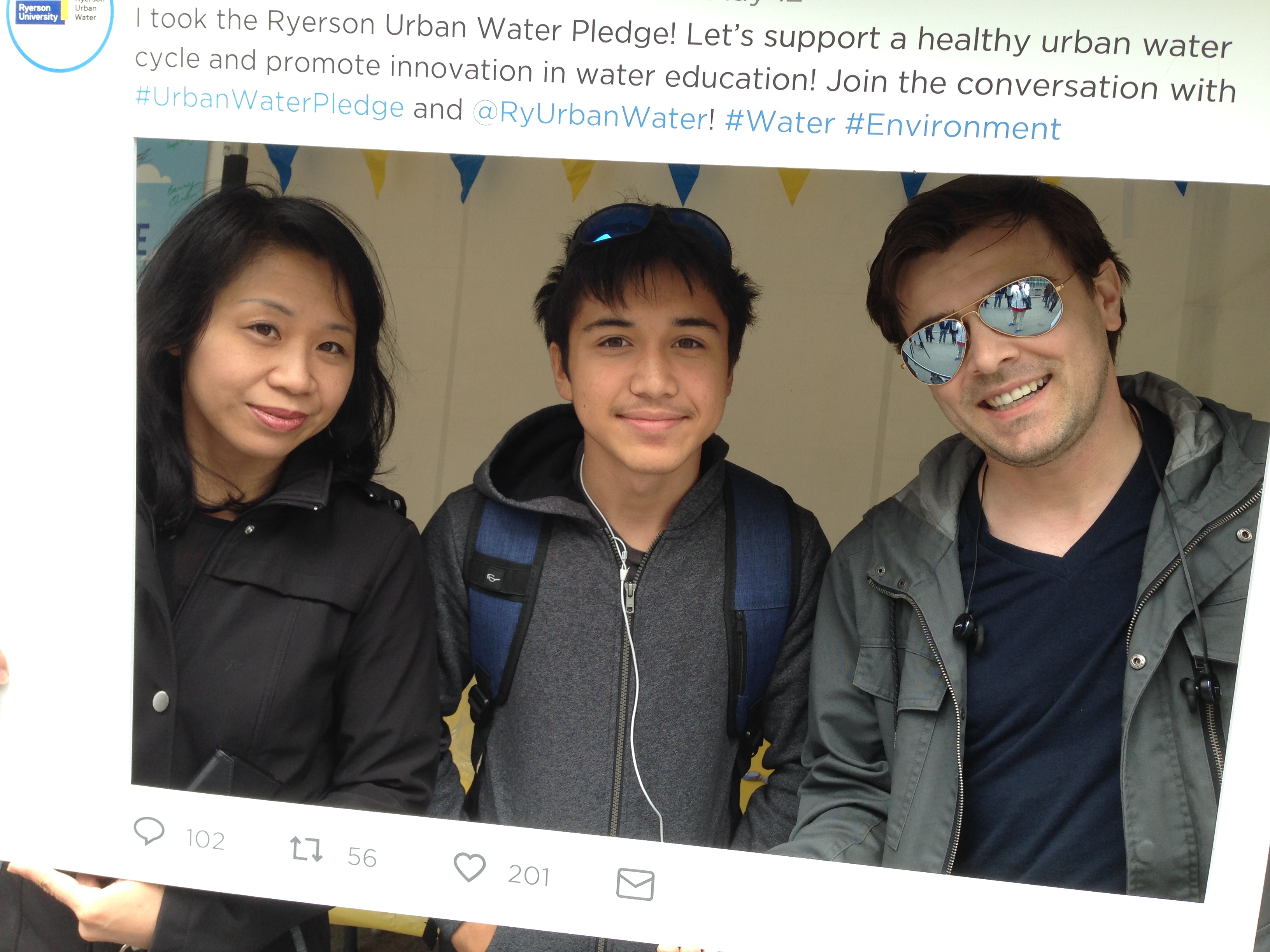 group of people posing within printed framed tweet