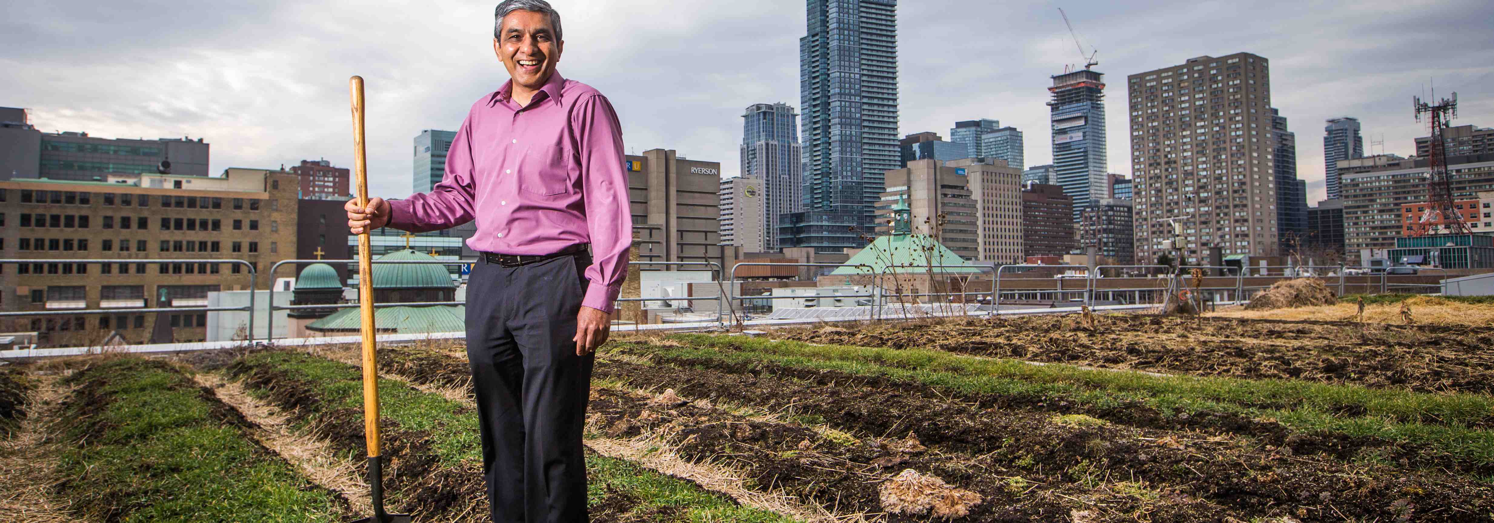 researcher posing with shovel in hand