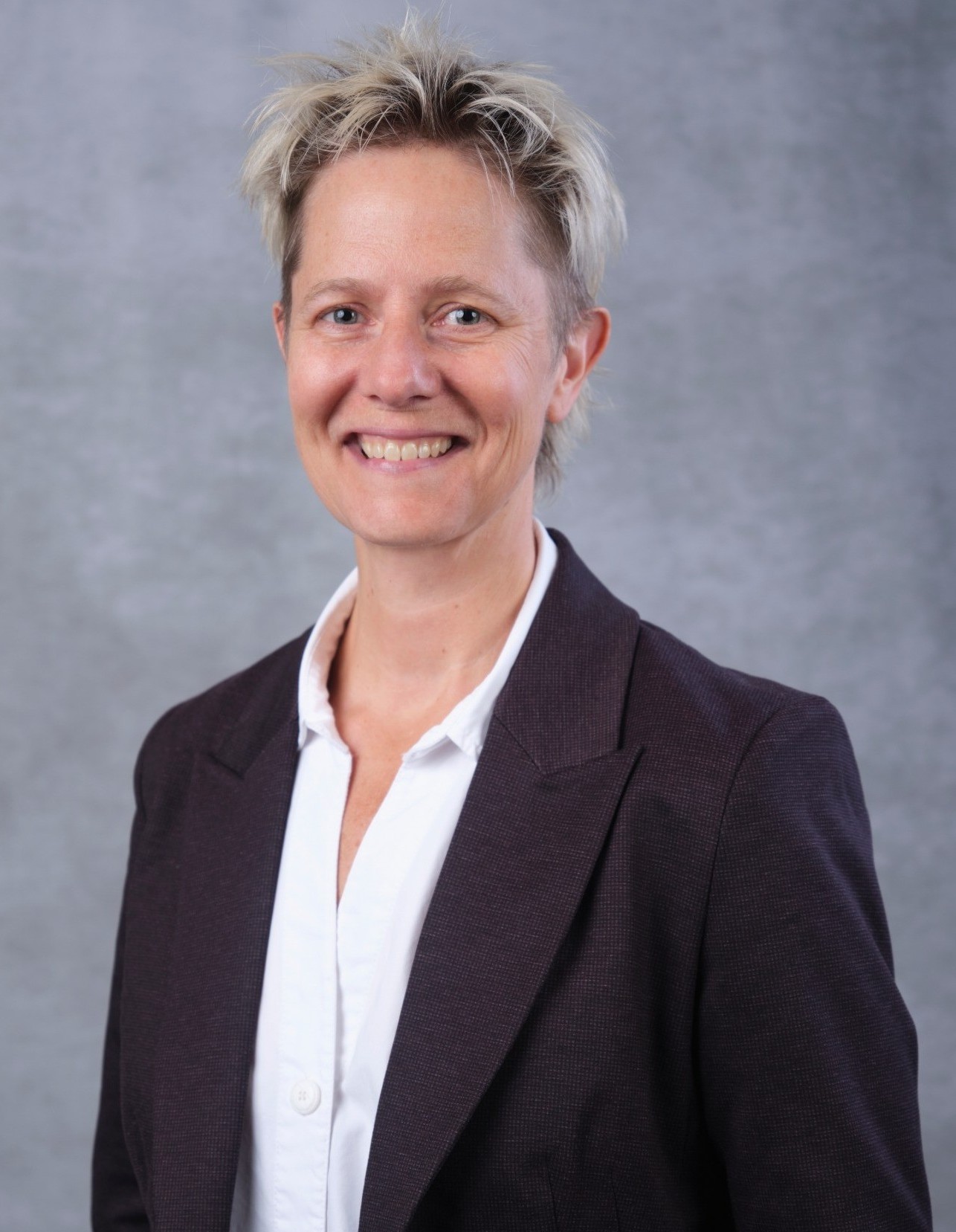 Jen McMillen  Vice-Provost, Students smiling in a black blazer and white shirt