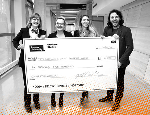 Four people are holding a large cheque and posing for the camera.