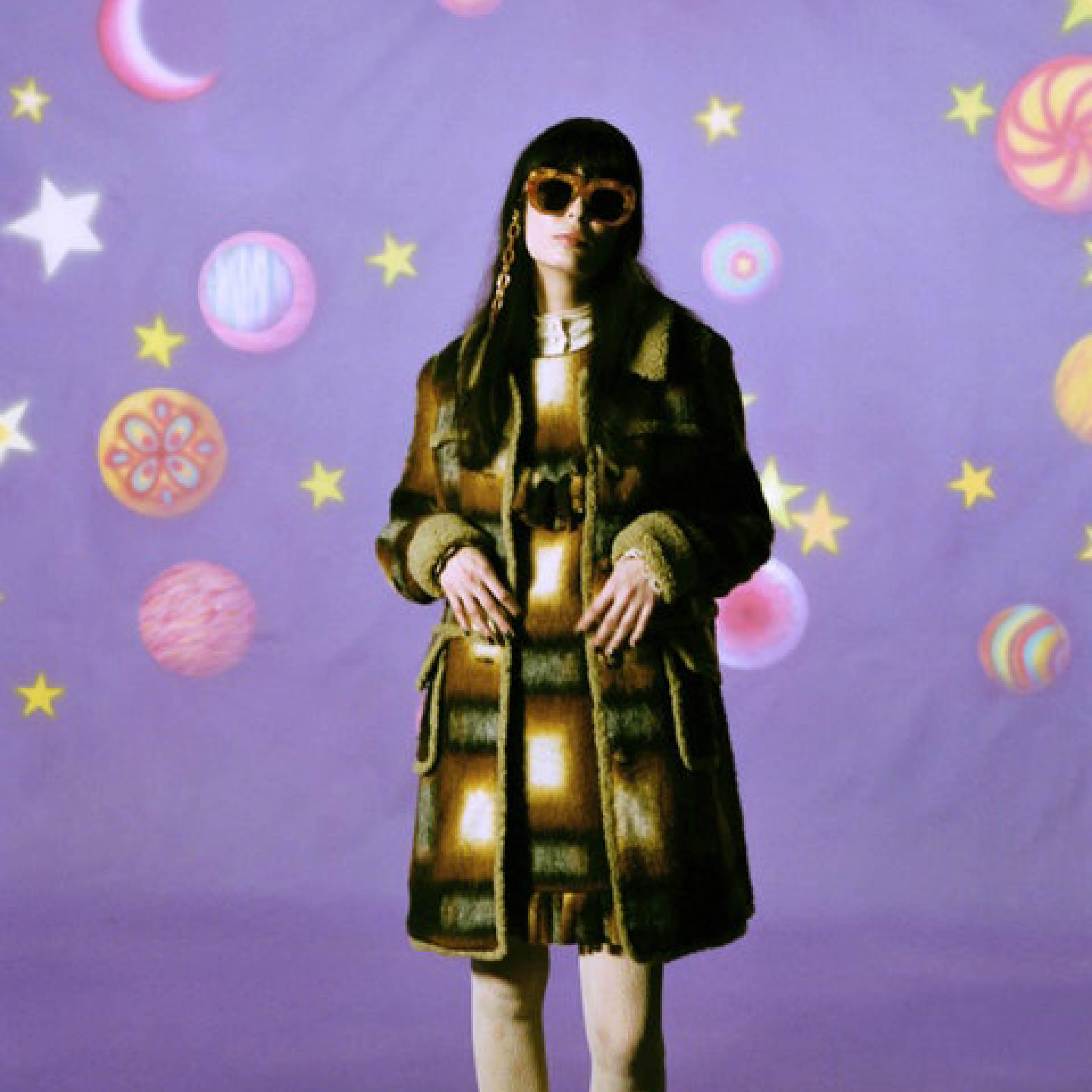 Models wearing Anna Sui clothes against purple background with planets.