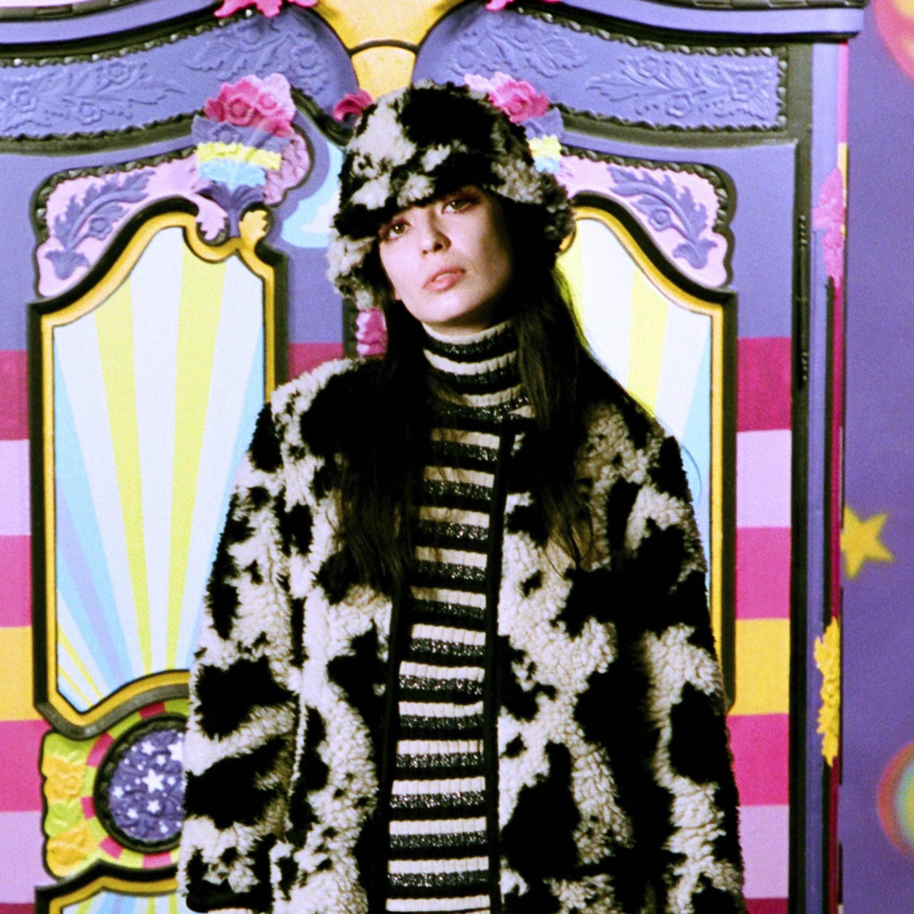 Models wearing Anna Sui clothes against purple wardrobe.