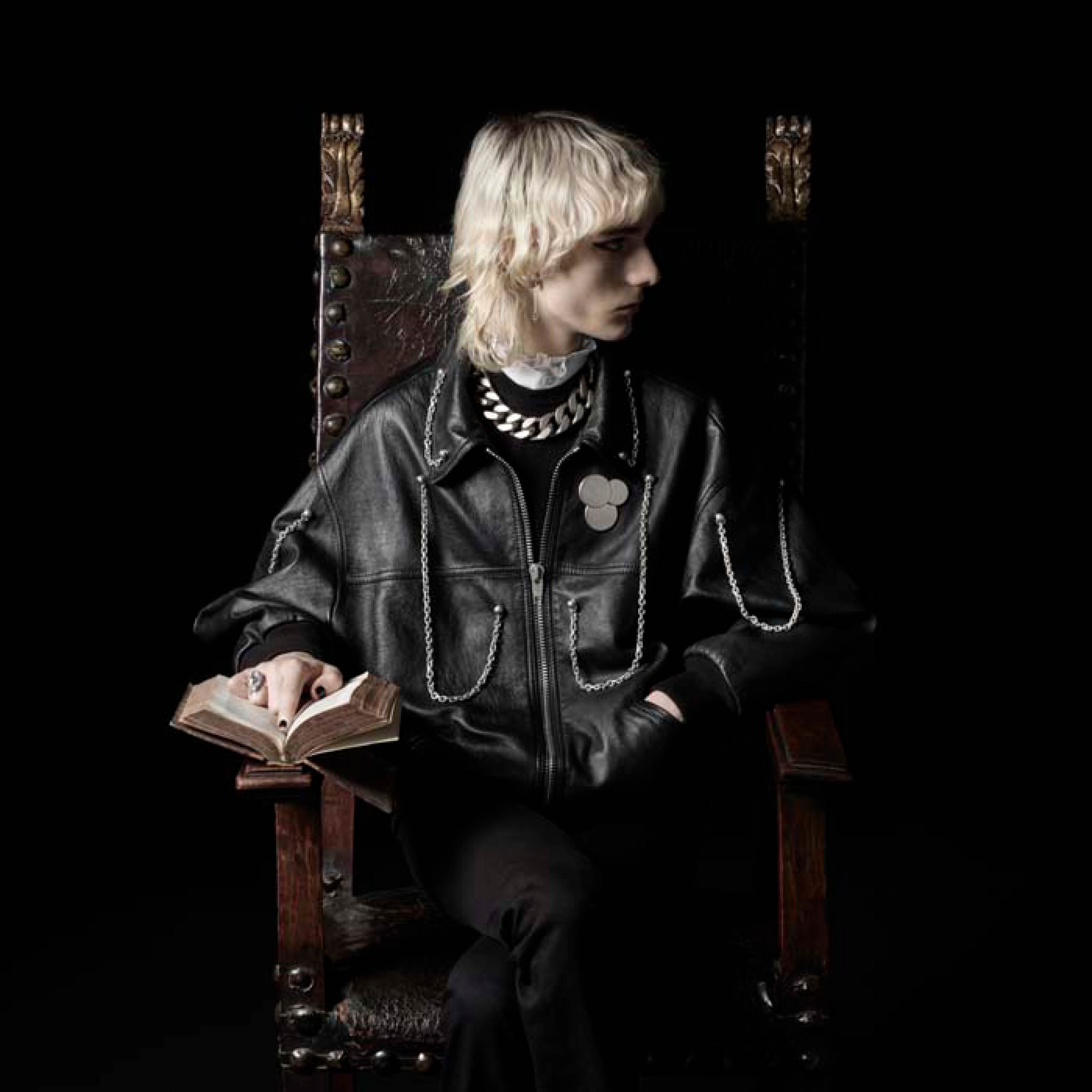 Man on a throne with Celine clothes.