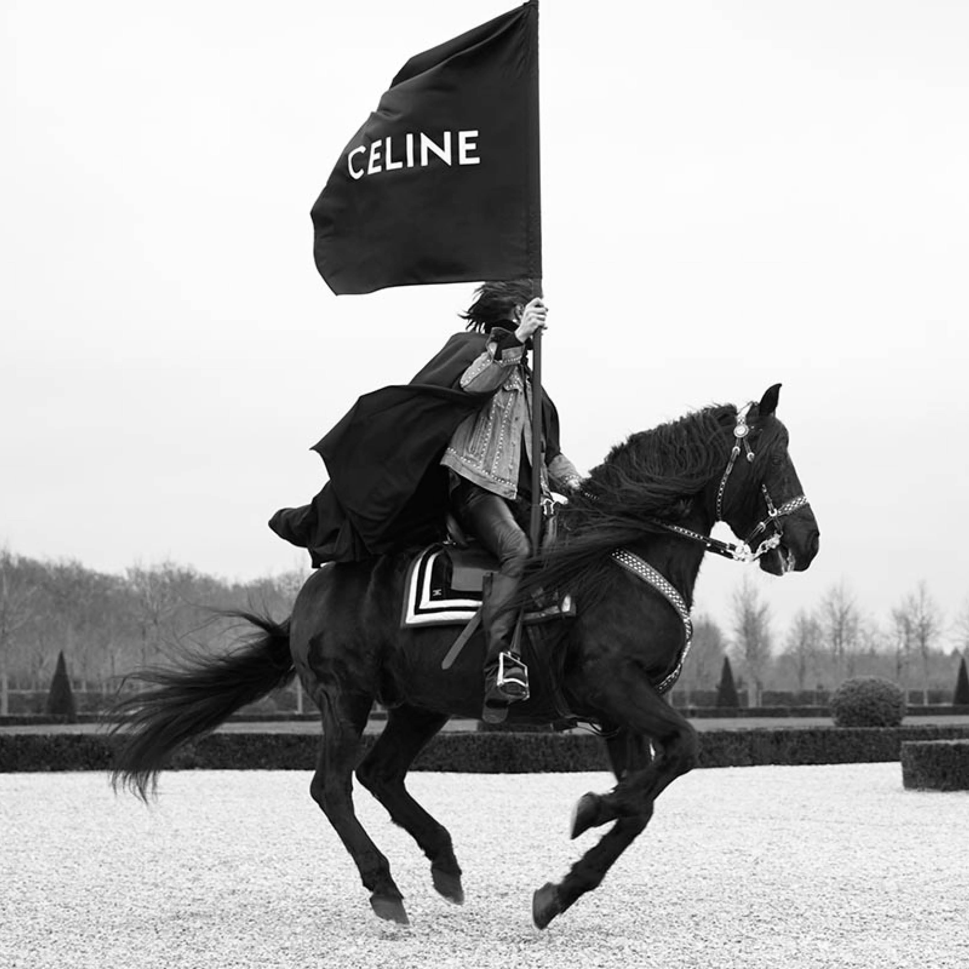 Man on horse carrying a flag with the Celine logo.