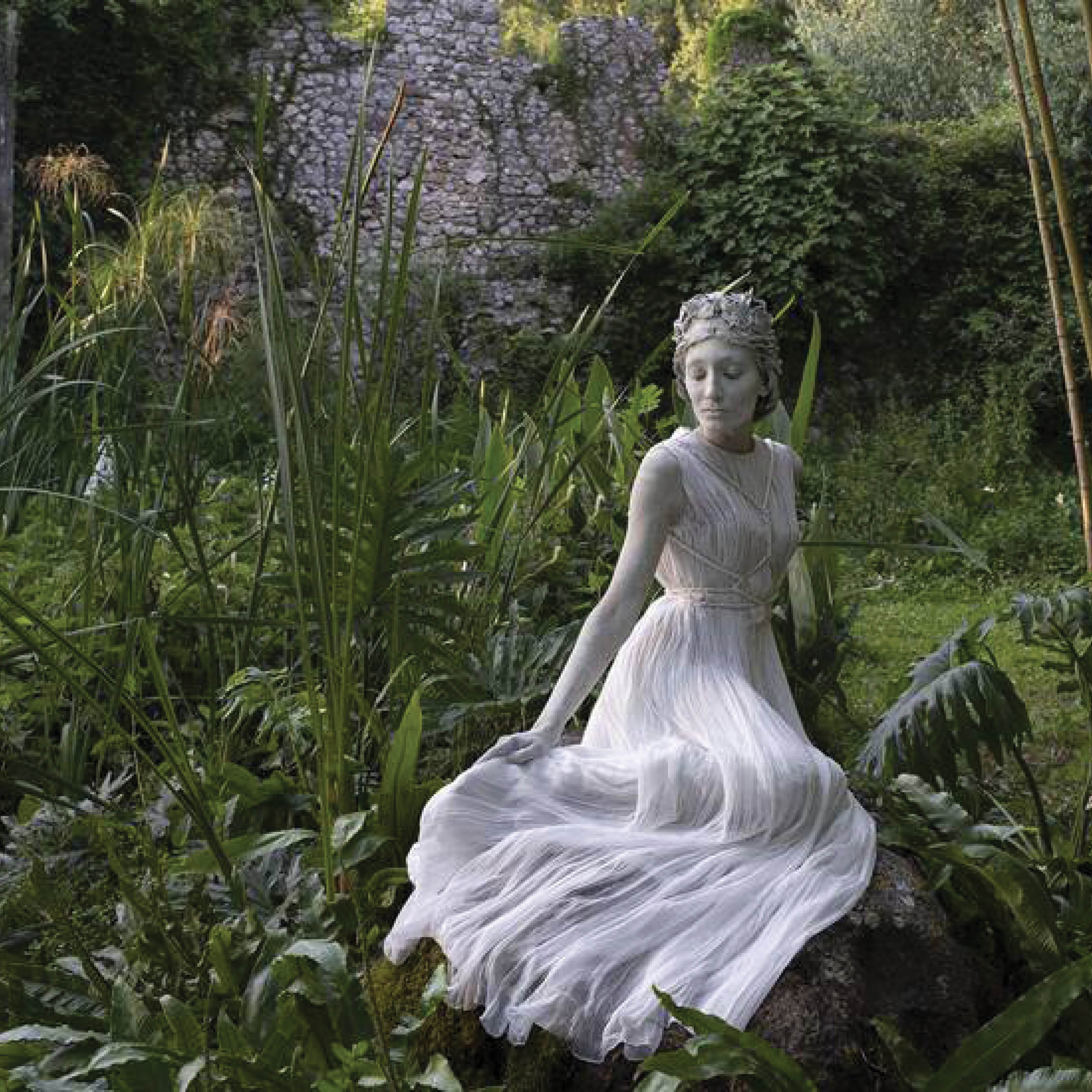 Dior model wearing a white dress in a forest photoshoot.