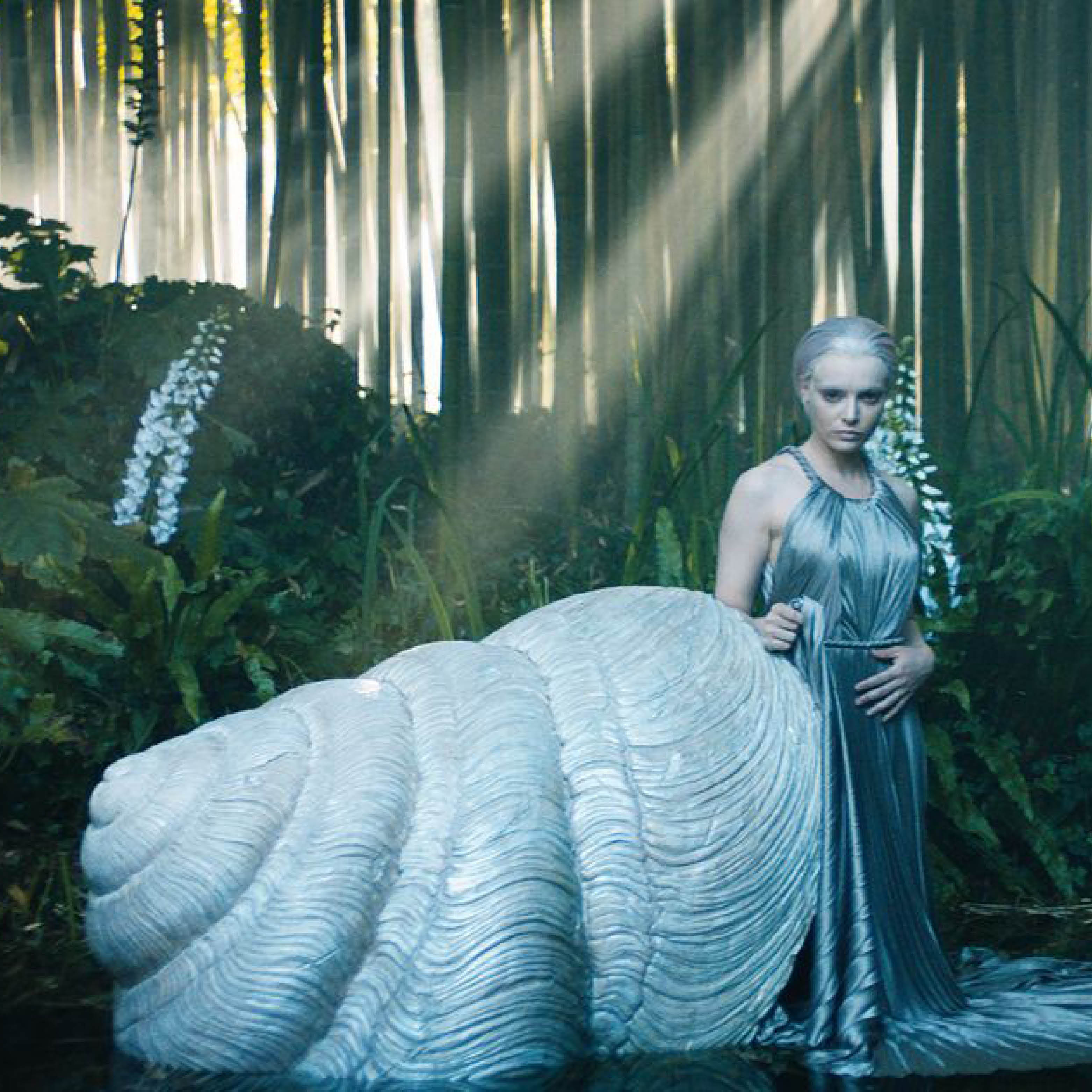 Dior model with a shell prop in a forest photoshoot.