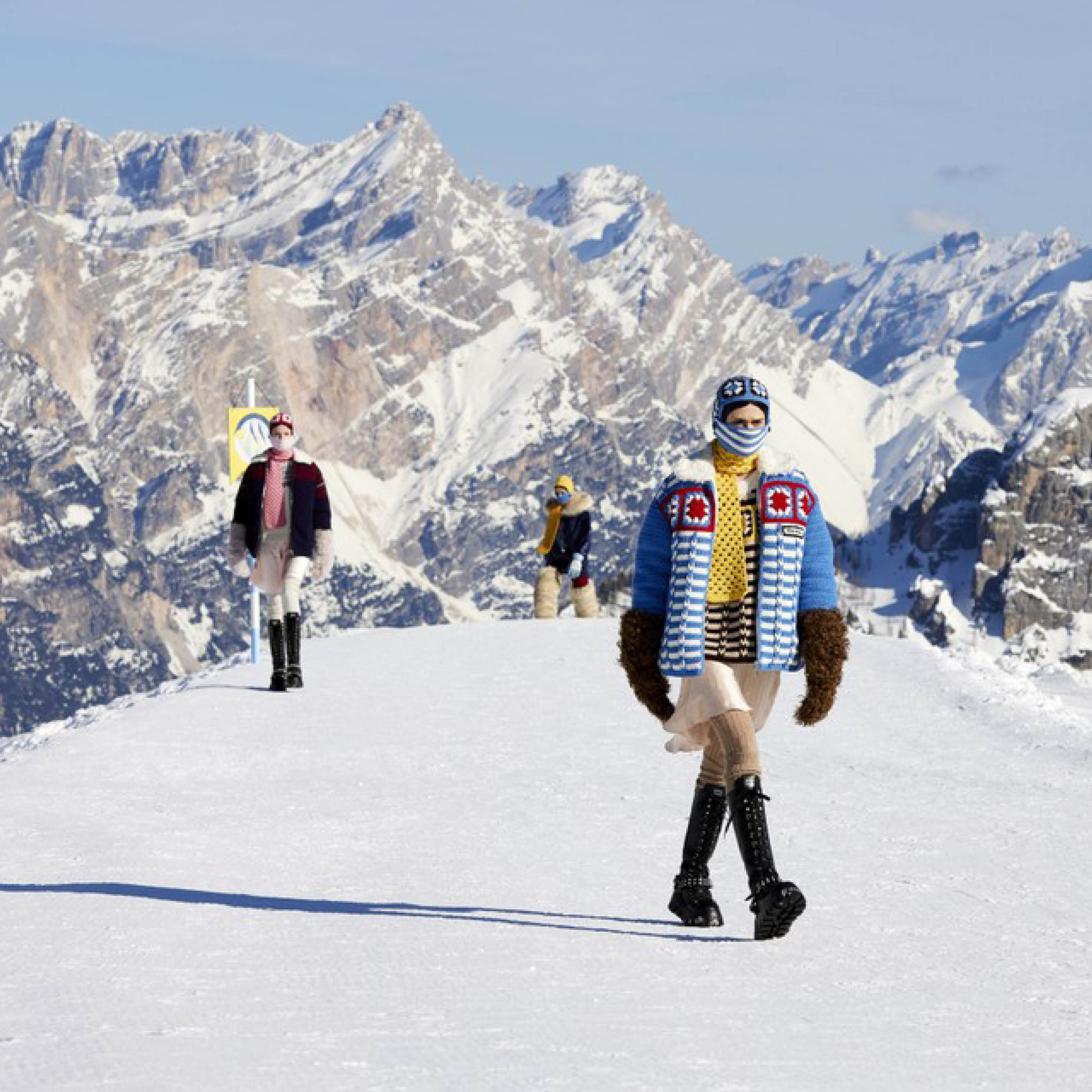 Miu Miu models in thick jackets atop of a snowy mountain.