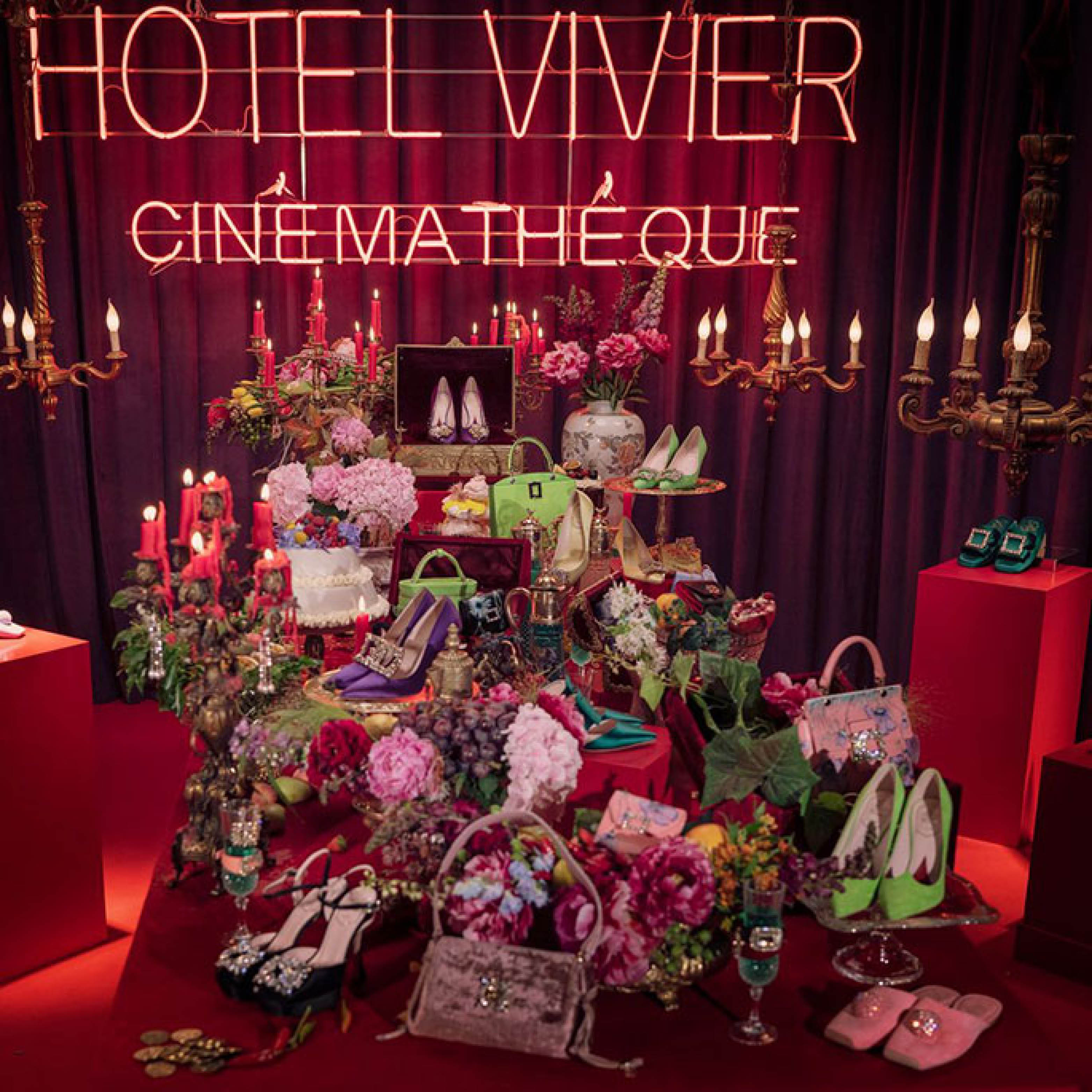 Shoes in front of a red Hotel Vivier Cinémathèque sign.