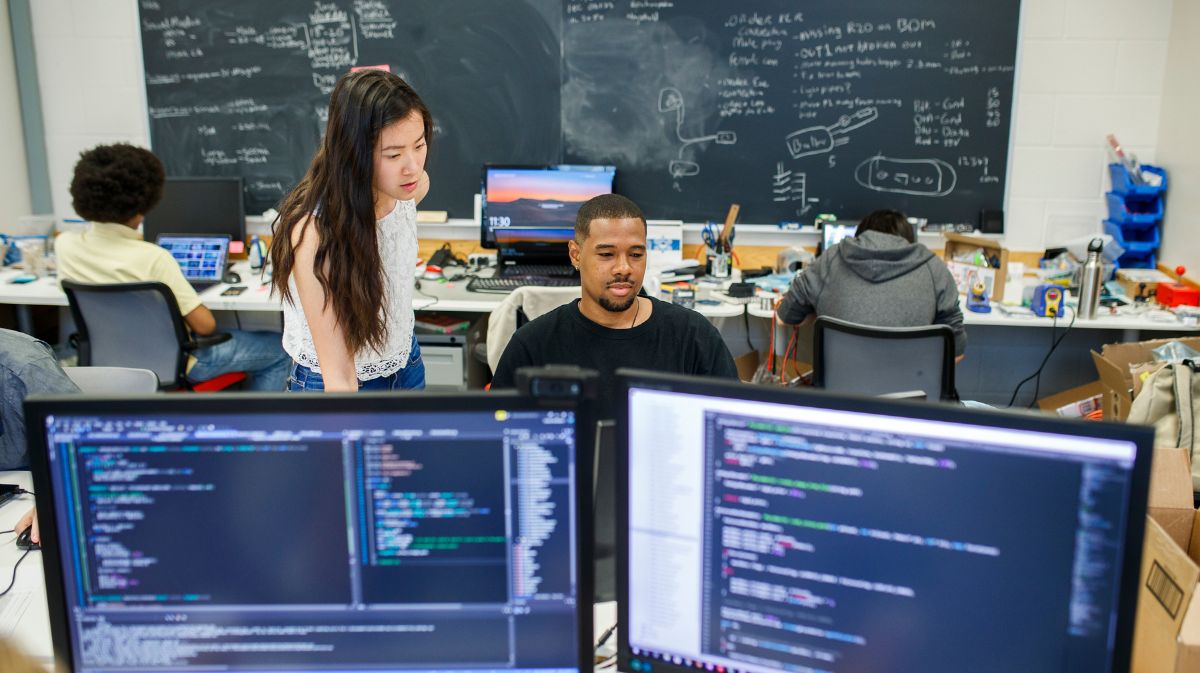 Two students working together on their laptops