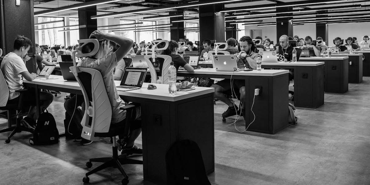 Black and white image of people in an office all working at desks on computers