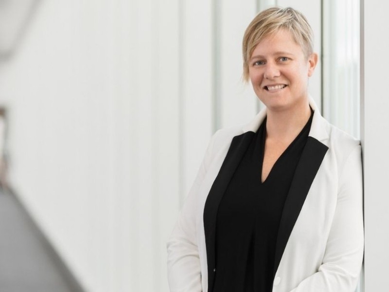 Jen McMillen, Vice-Provost, Students smiles in a black shirt and white blazer