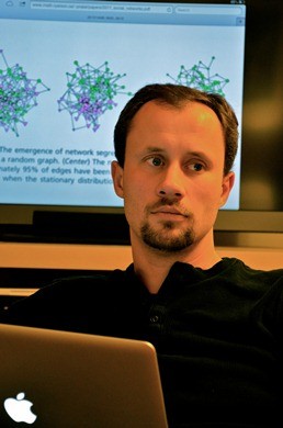 Pawal Pralat sitting in front of computer screen showing model of complex graph network