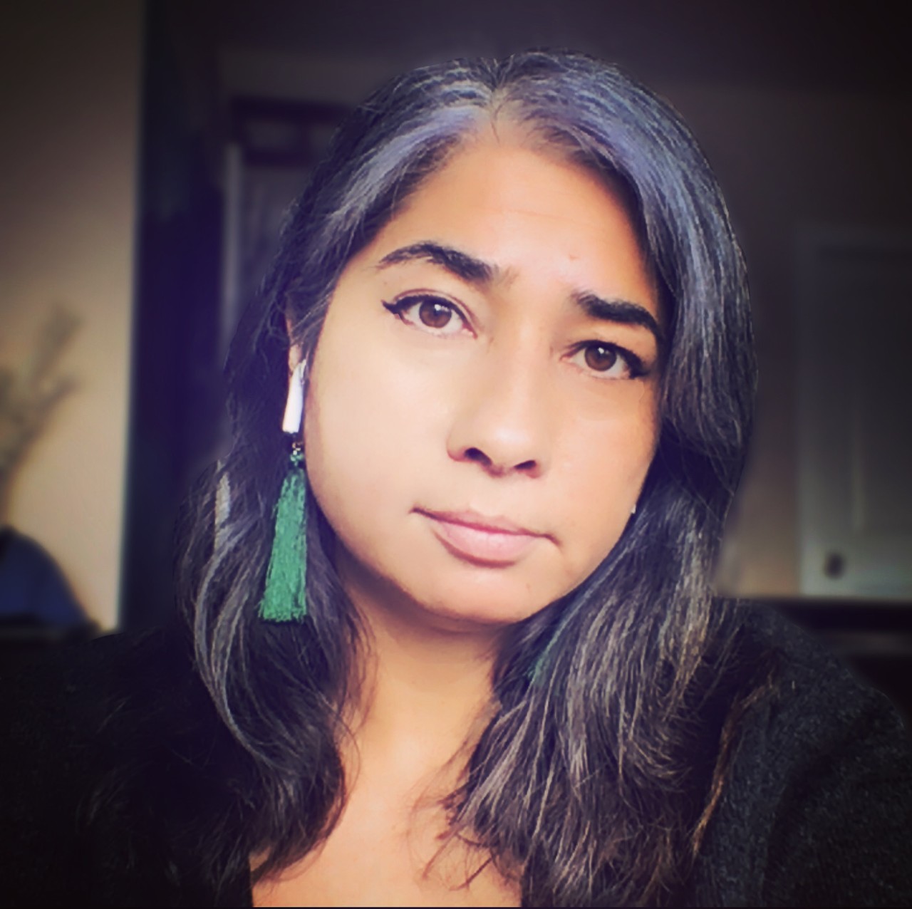 Headshot of Angela Misri, titlted head with coloured hair and smiling