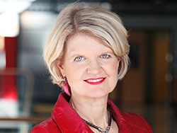 Headshot of Janice Neil, smiling with red top