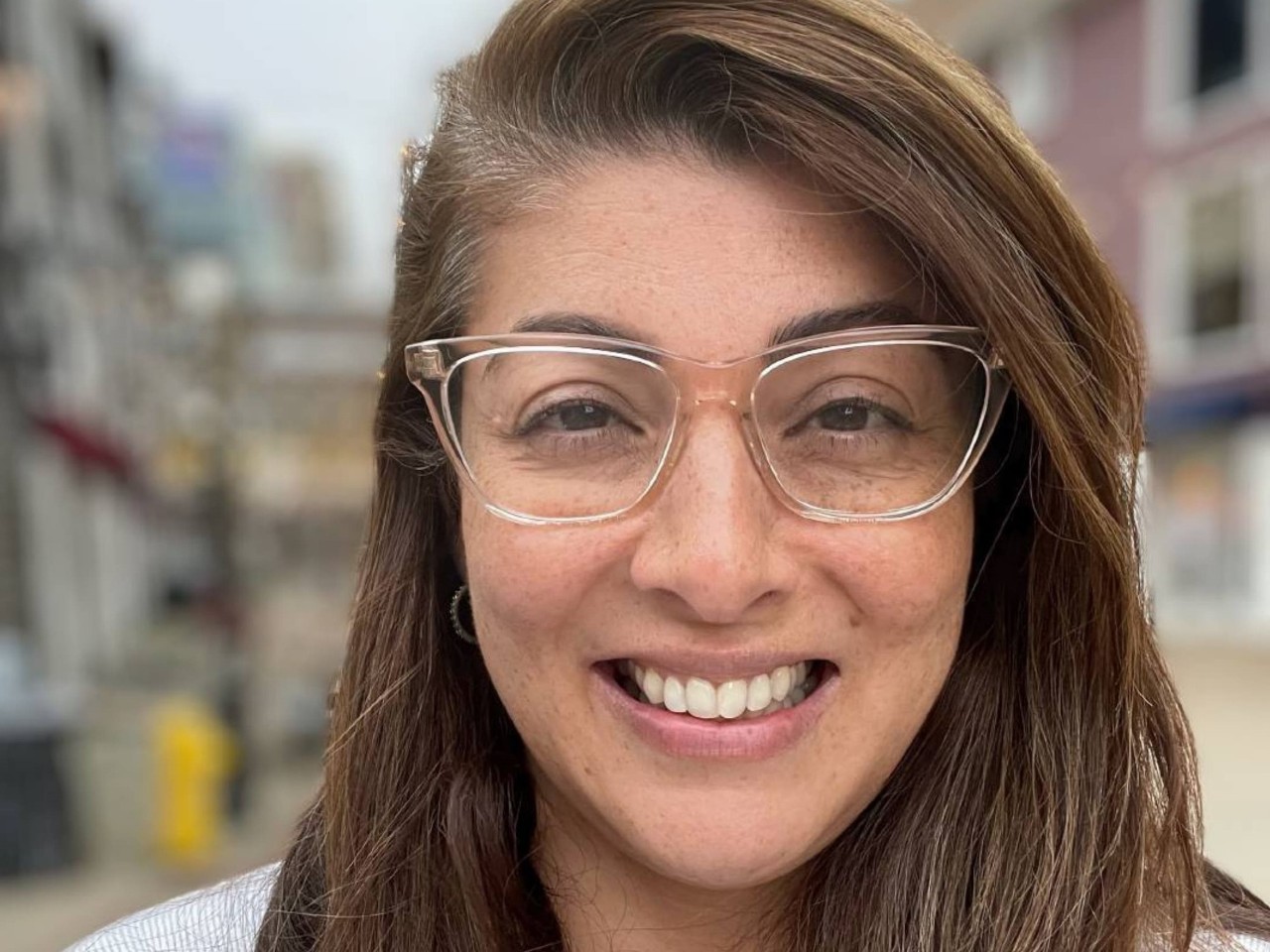 Anupam Singh wearing glasses close up of face with a blurred background.