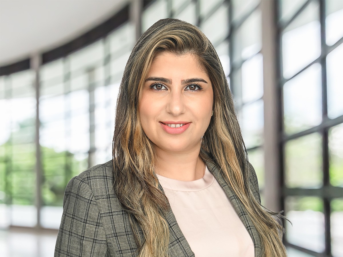 Shaghayegh Shajari smiling in business attire with a glass wall behind her.