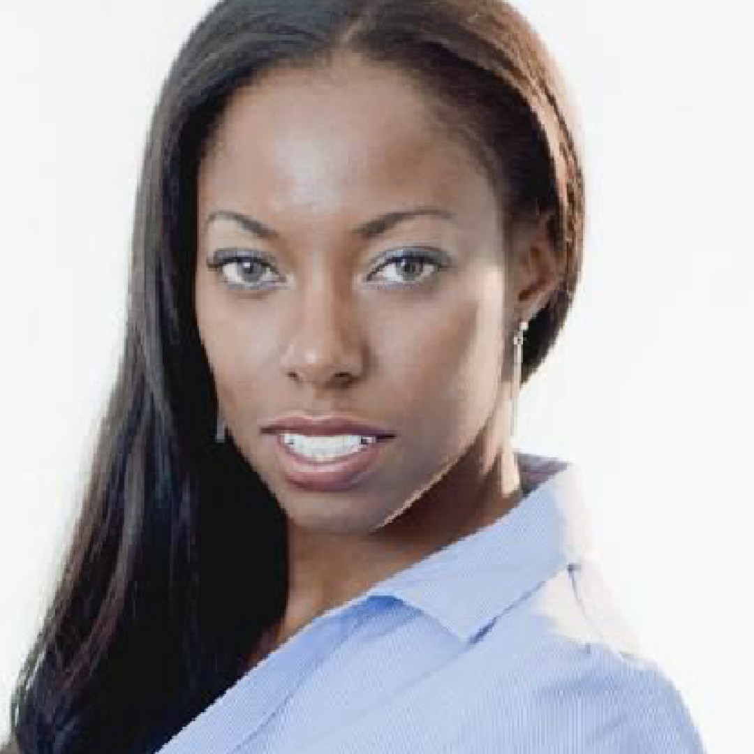 Close-up headshot of Nicole Forrester with a neutral expression. She has long straight hair and is wearing a light blue collared shirt with drop earrings.