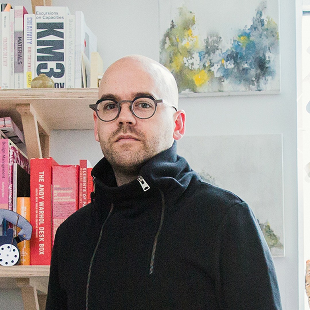 Headshot of Jonathon Anderson wearing black sweater and glasses
